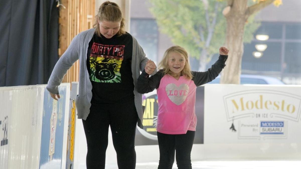 Hanna Thorington (left) ice skates with Mia Thorington (right, age 9) during the opening of an ice skating rink in Modesto in November.