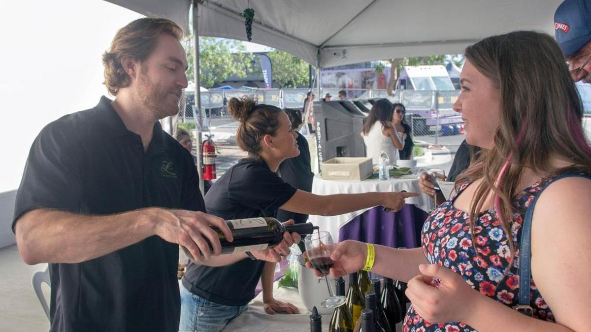 Shea Ridge of Lucca Winery, left, pours a glass of wine for Amy Best during the Riverbank Cheese and Wine Expo in 2015. This year’s event is Saturday and Sunday, Oct. 8-9, 2016, in downtown Riverbank.