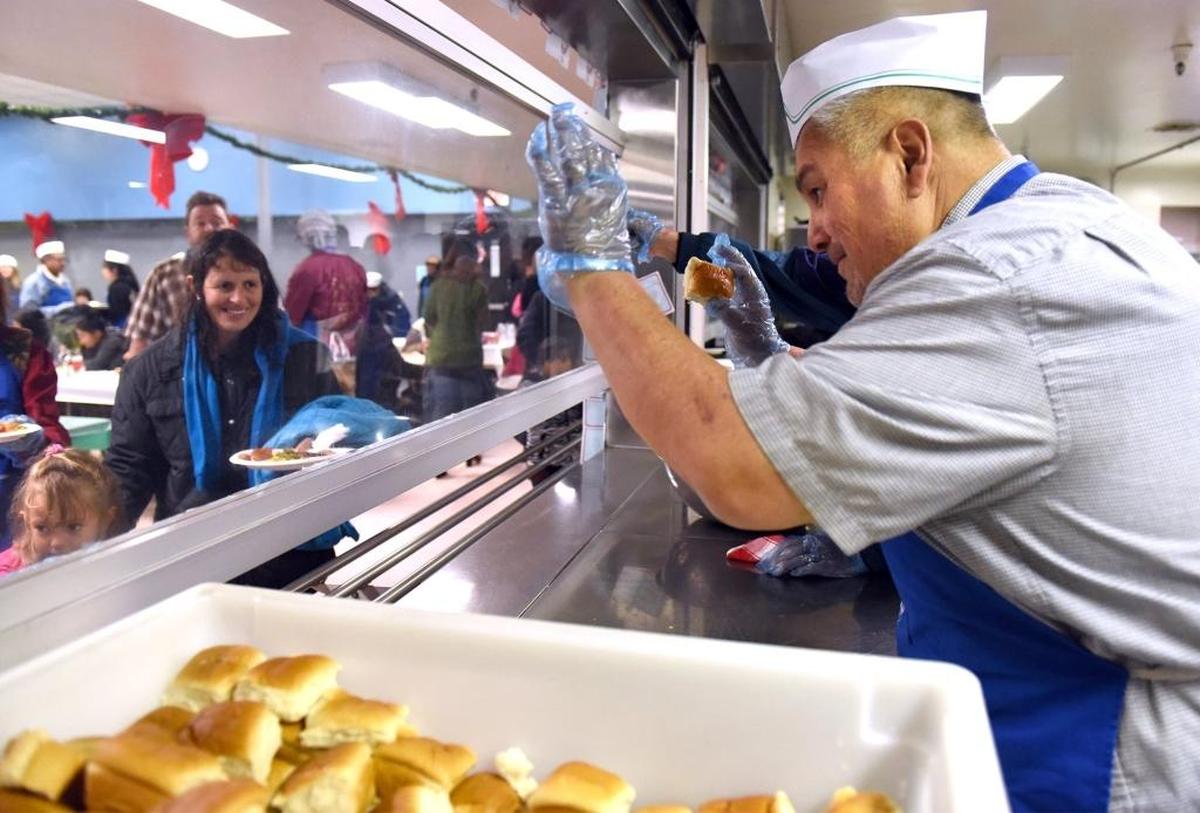 A volunteer gives out rolls at the 2016 Happy Birthday Jesus party at the Modesto Gospel Mission.