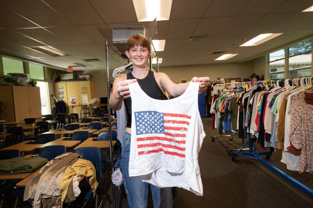 Thrift Club member Ruby Linn shows off a new donation at the Turlock High School store on Wednesday, Aug. 20, 2025.