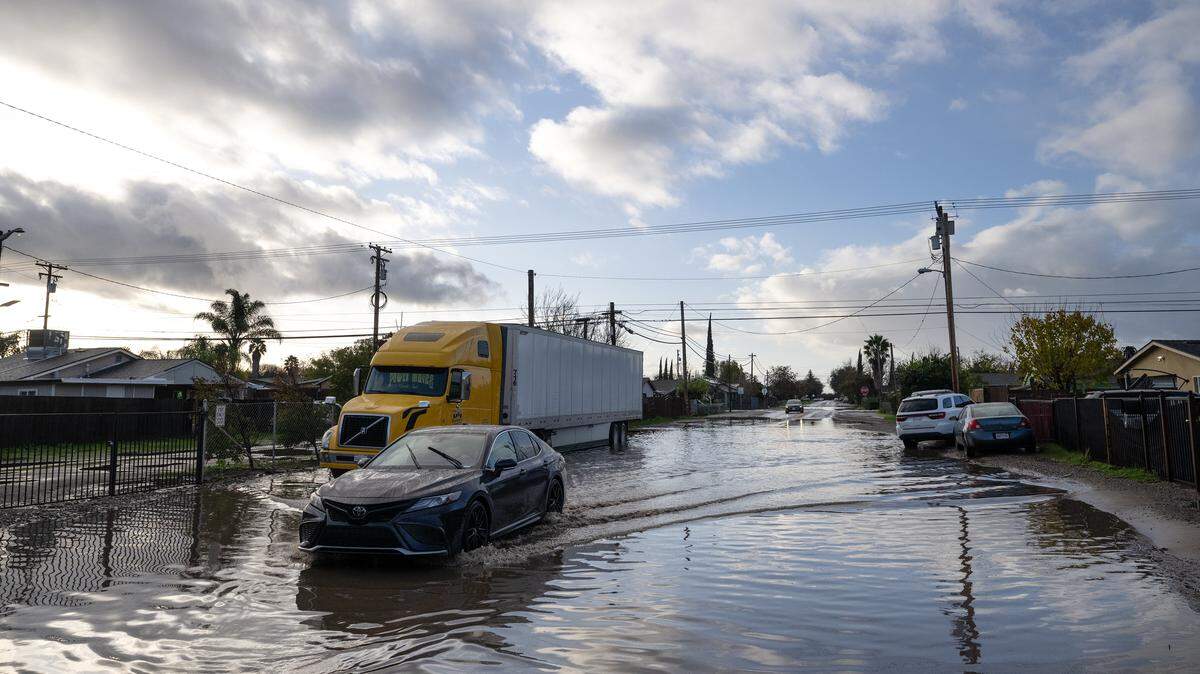 A motorist navigates through a flooded Dallas St. in Modesto, Thursday, Dec. 25, 2025.
