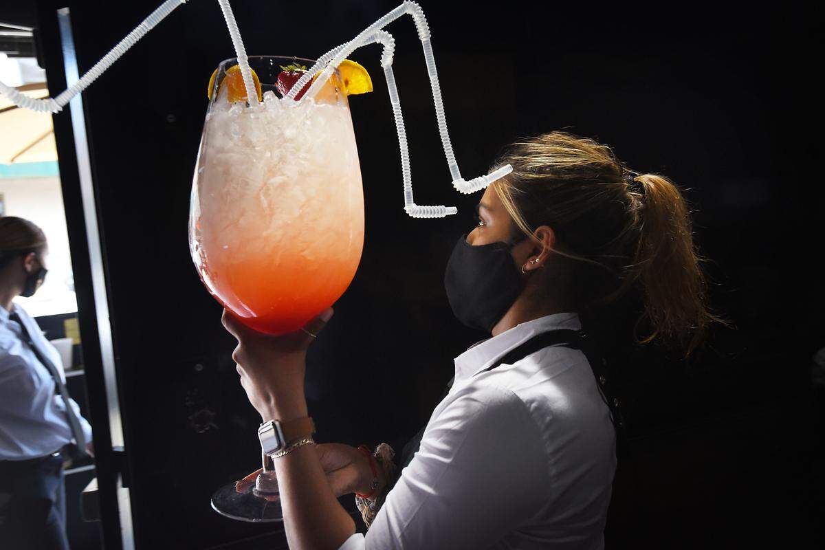 Server Vanessa Chavez delivers a Mega Mimosa at My Mimosas restaurant in Modesto, Calif., on Friday, Aug. 14, 2020.