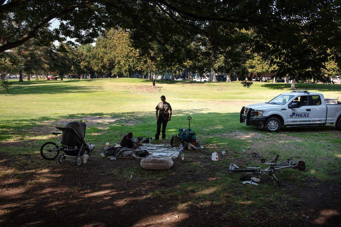Modesto park ranger Justin Rocha talks with a man in Downey Park in Modesto, Calif., on Friday, September 9, 2022.
