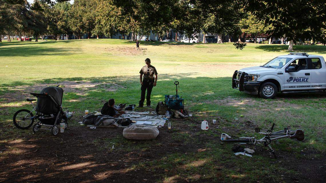 Modesto park ranger Justin Rocha talks with a man in Downey Park in Modesto, Calif., on Friday, September 9, 2022.