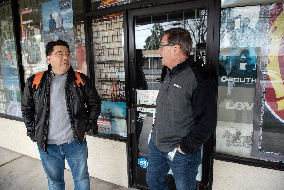 Modesto councilmember Nick Bavaro, right, talks with Carver Road business owner Dale Jin Yoo, left, in Modesto, Calif., Wednesday, March 29, 2023.