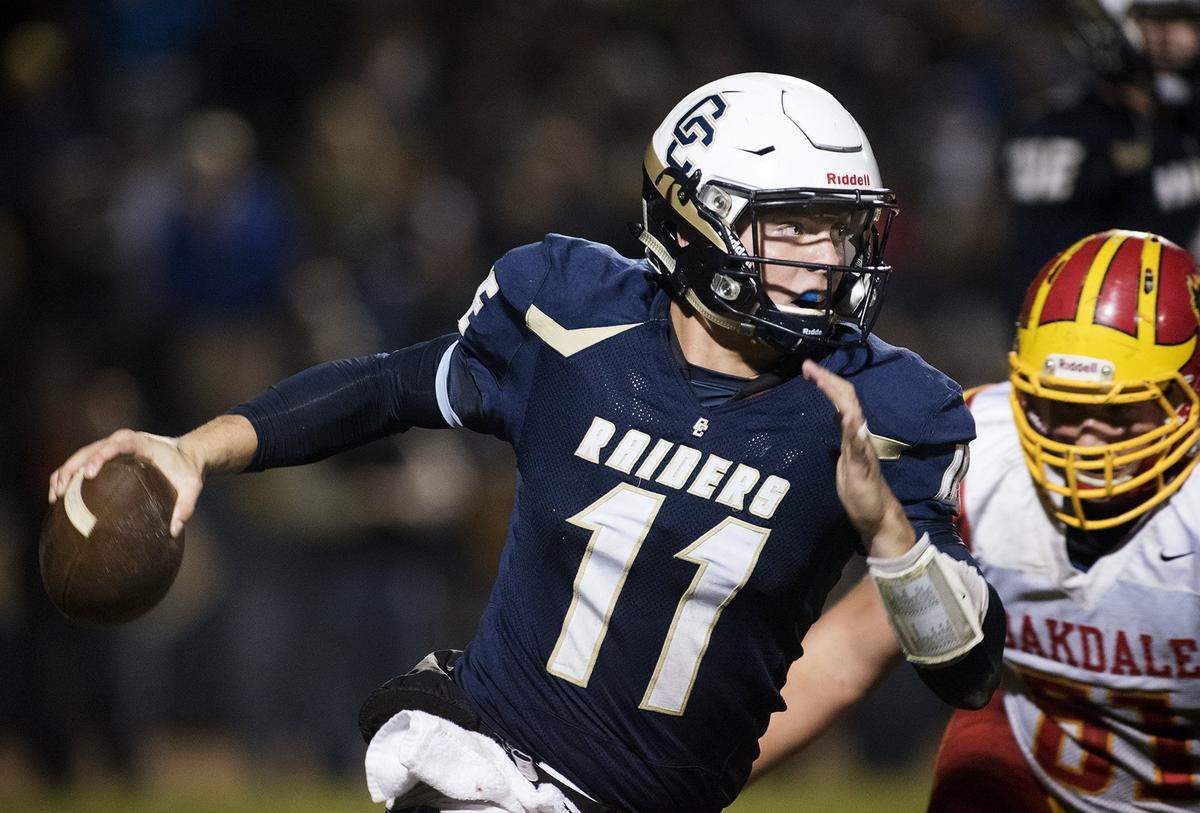 Central Catholic quarterback Hunter Petlansky scrambles under pressure from Oakdale's defense during the Valley Oak League game at Central Catholic High School in Modesto, Calif., on Friday, Nov. 6, 2015.