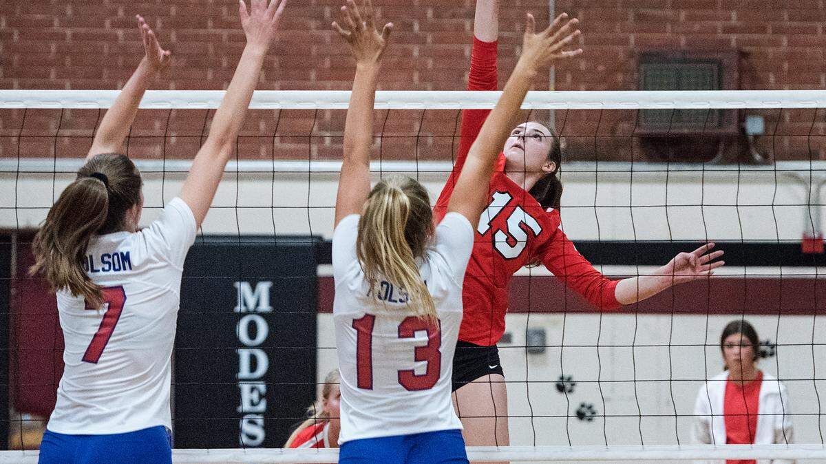 Modesto’s Hannah Scott floats the ball over Folsom’s Sydney Radell (7) and Lauren Thompson (13) during the Sac Joaquin Section playoff game at Modesto high School in Modesto, Ca., on Tuesday, Oct. 23, 2018.