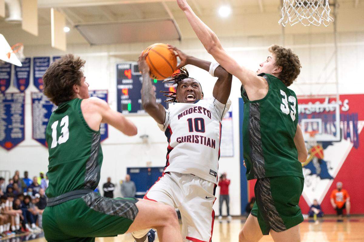 Modesto Christian’s BJ Davis challenges De La Salle’s Evan Wells (13) and Alec Blair (33) during the NorCal Open Division semifinal playoff game in Salida, Calif., Saturday, March 4, 2023. Modesto Christian won the game 57-56.