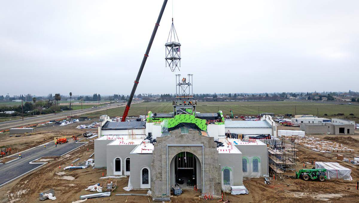 A crew installs the final section of the tower at the Church of Jesus Christ of Latter-day Saints new temple on Dale Road in Modesto, Thursday, Dec. 19, 2024.