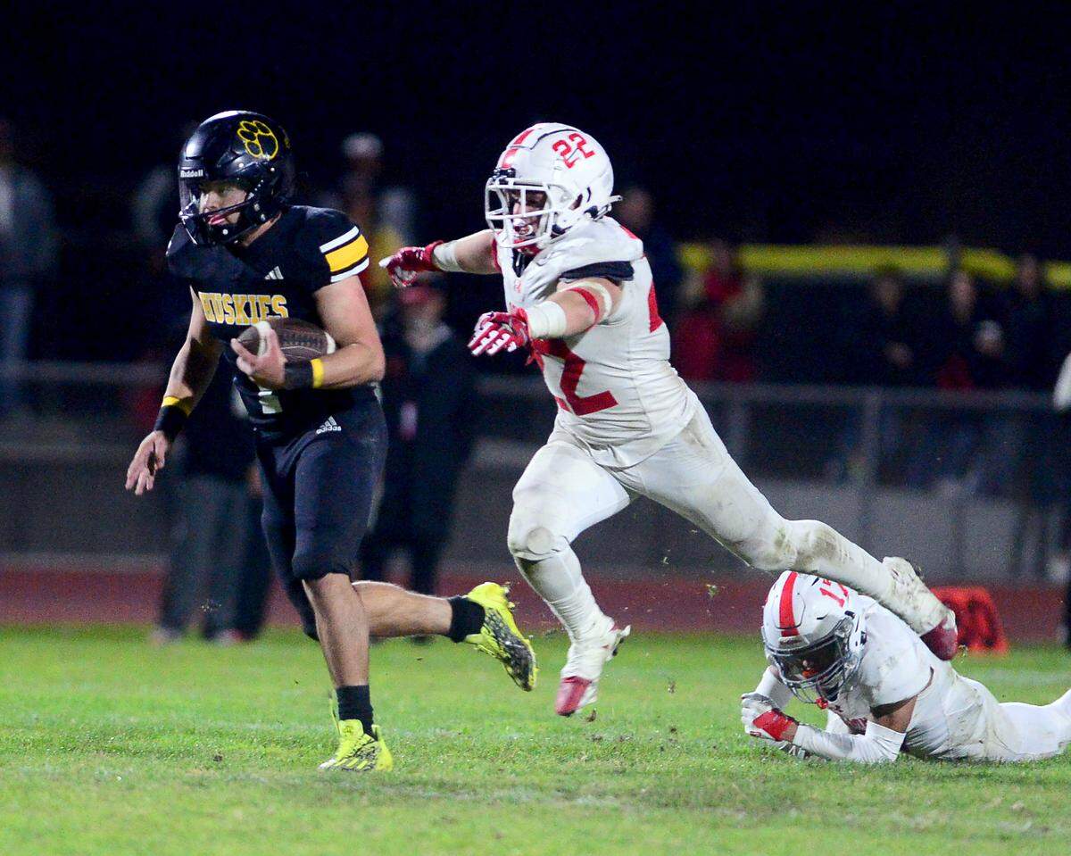 Hughson running back Alexander Villarreal (1) sprints away from a Palma defender Noah Orozco (22) during a 2023 CIF Division 4-A Northern California Bowl game between Hughson and Palma at Hughson High School in Hughson, Calif. on Saturday, Dec. 2, 2023. Palma won the game 31-21.