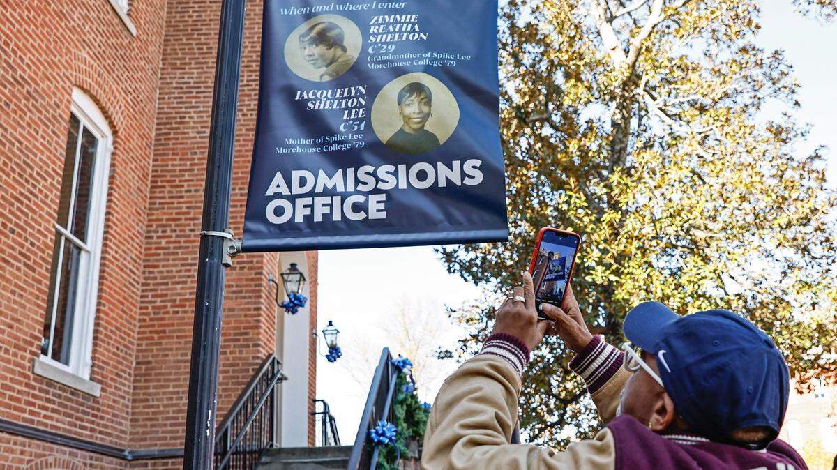 Film director Spike Lee takes a photo of signs for the admissions office dedicated to his mother and grandmother at Spelman College on Nov. 28, 2022, in Atlanta.