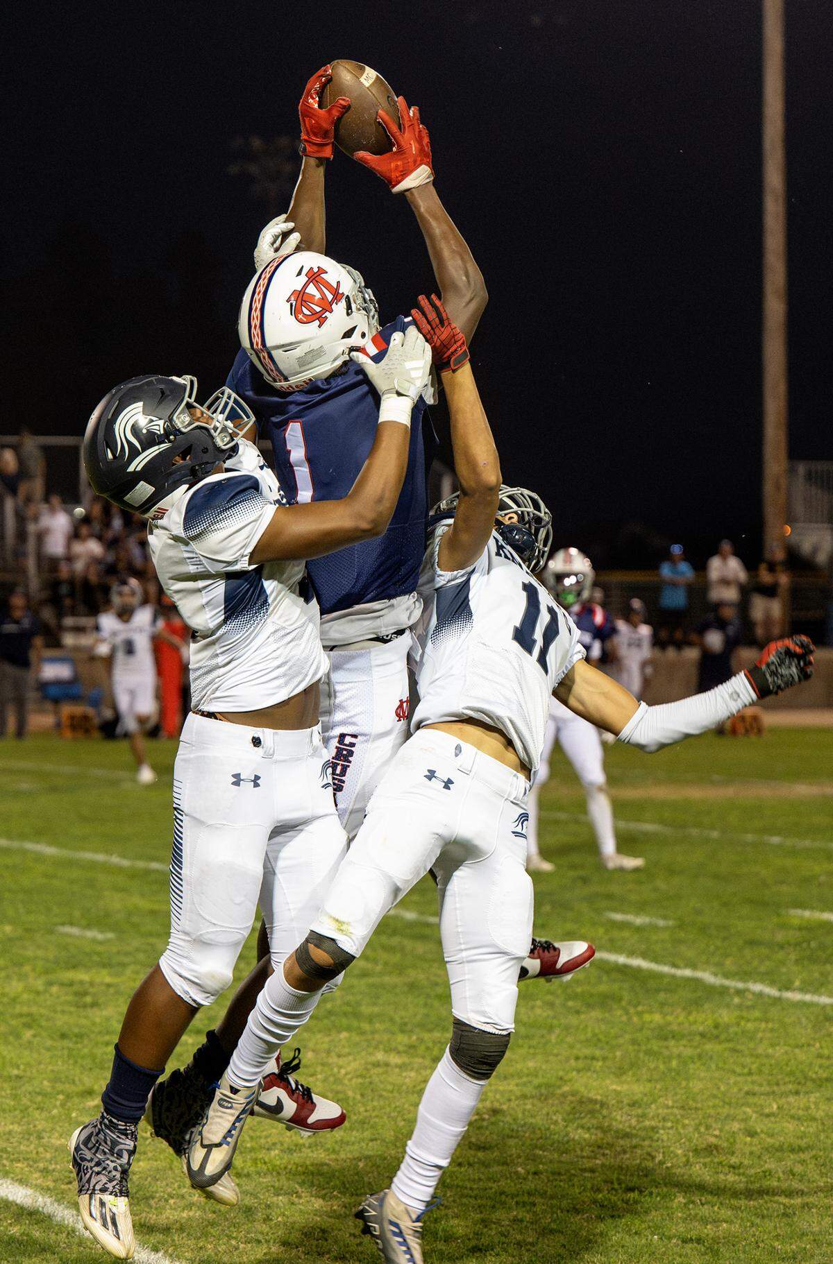 Modesto Christian’s Jeremiah Bernard makes a grab above Stone Ridge Christian’s Sawyer Wood (11) and Daijon O’Neil during the nonleague game at Modesto Christian High School in Salida, Calif., Friday, Sept. 15, 2023.