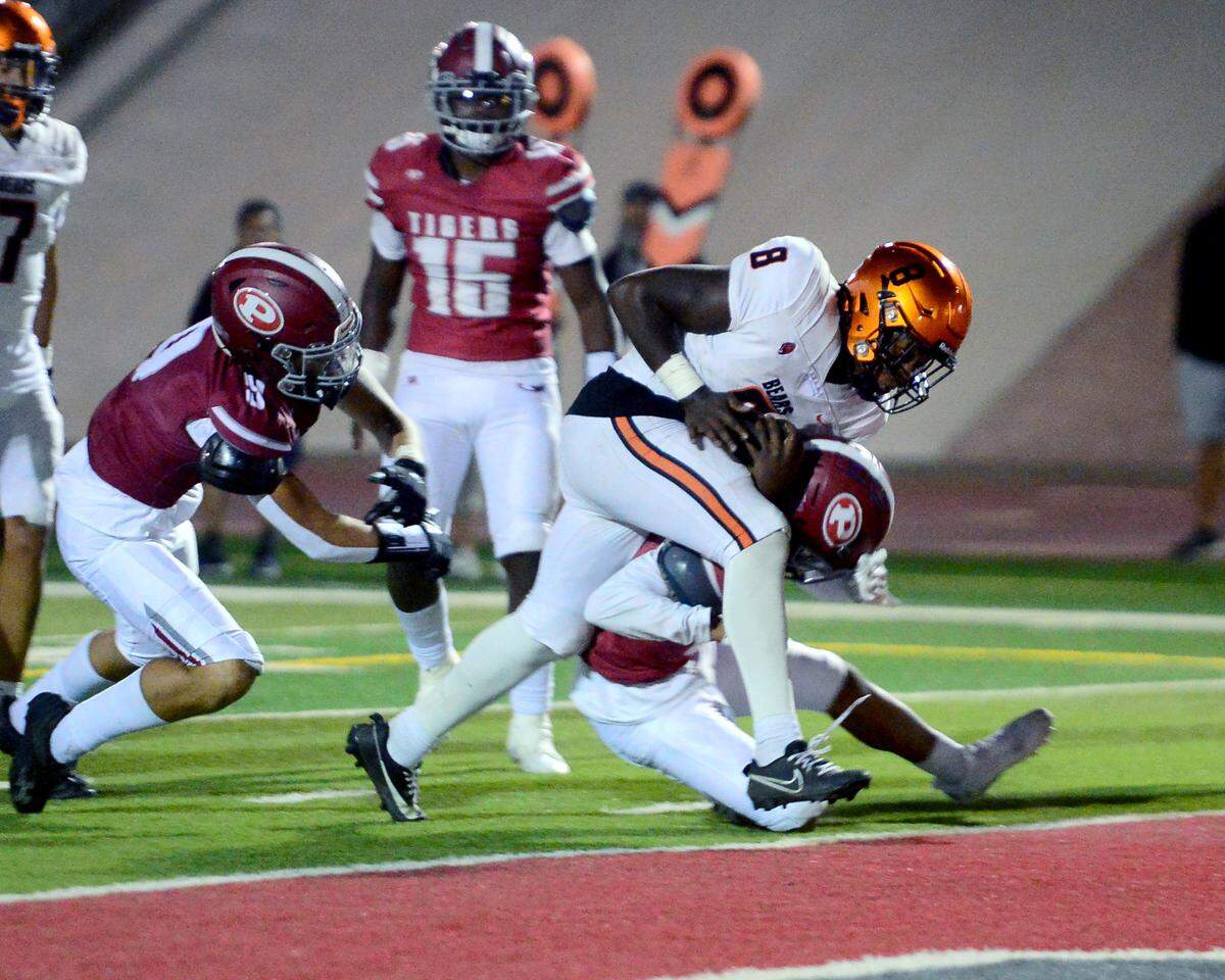 Merced running back Cammarri Jackson (8) takes a hit from a Patterson defender while scoring a touchdown during a game between Patterson High School and Merced High School at Patterson High on Aug. 23, 2024.