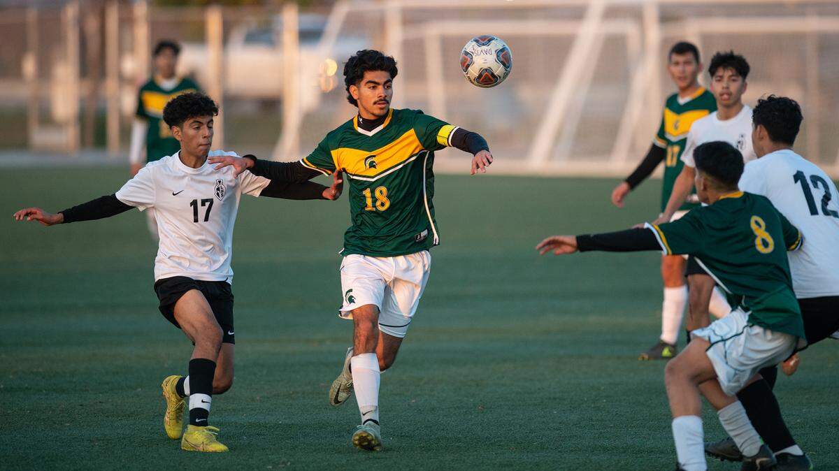 Davis Hjgh’s Adrian Valencia (18) and Lathrop’s Andres Hurtado-Garcia (17) pursue a loose ball during a Western Athletic Conference game at Mary Grogan Park in Modesto, Calif., Friday, Dec. 16, 2022.