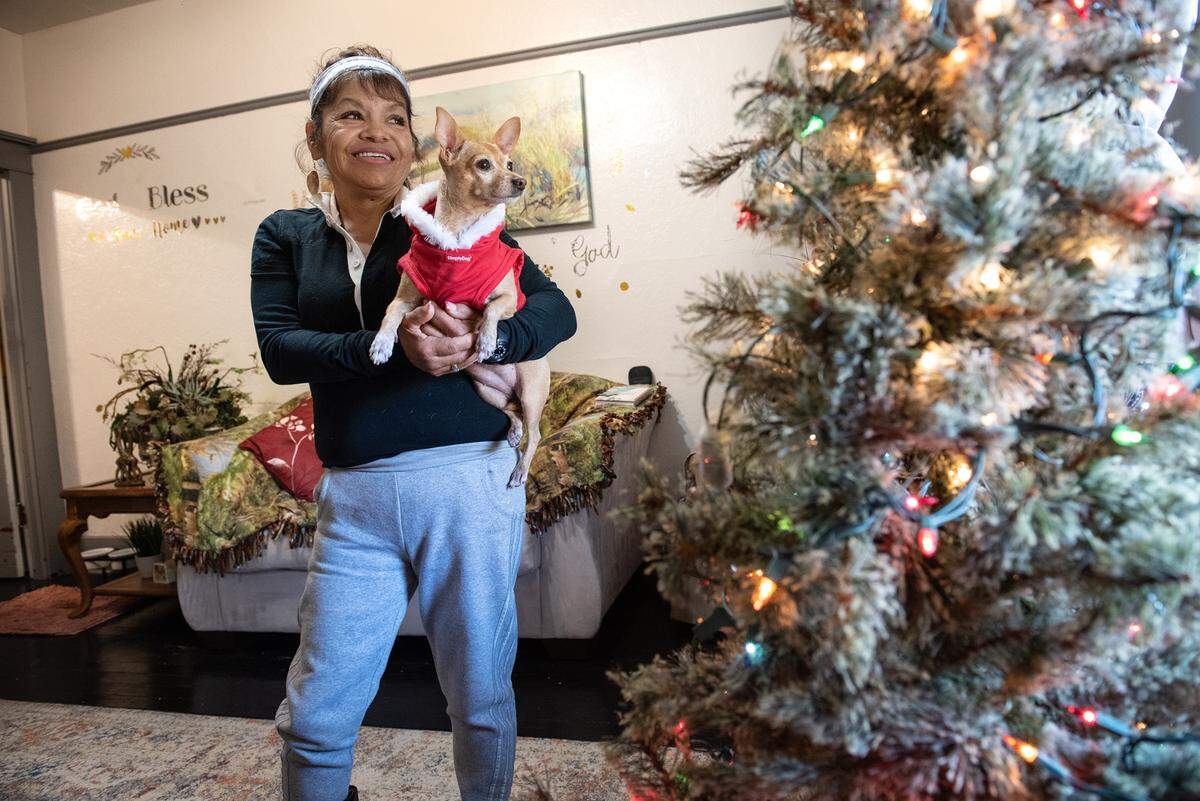 Lupe Vargas holds her dog Nana at her apartment in Modesto, Calif., Wednesday, Nov.16, 2022. Formerly homeless, Vargas received an emergency housing voucher, she says it changed her life.