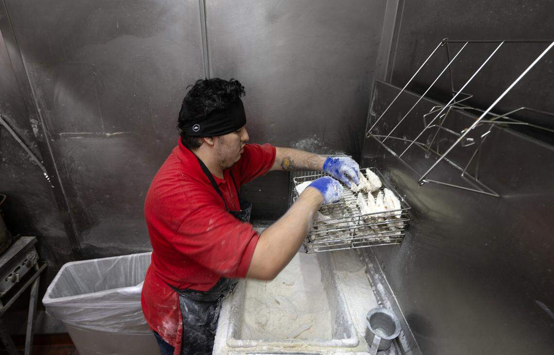 Cook Damien (first name only) prepares potato wedges for the fryer at Chicken Barn restaurant in Modesto, Calif., Thursday, Sept. 21, 2023.