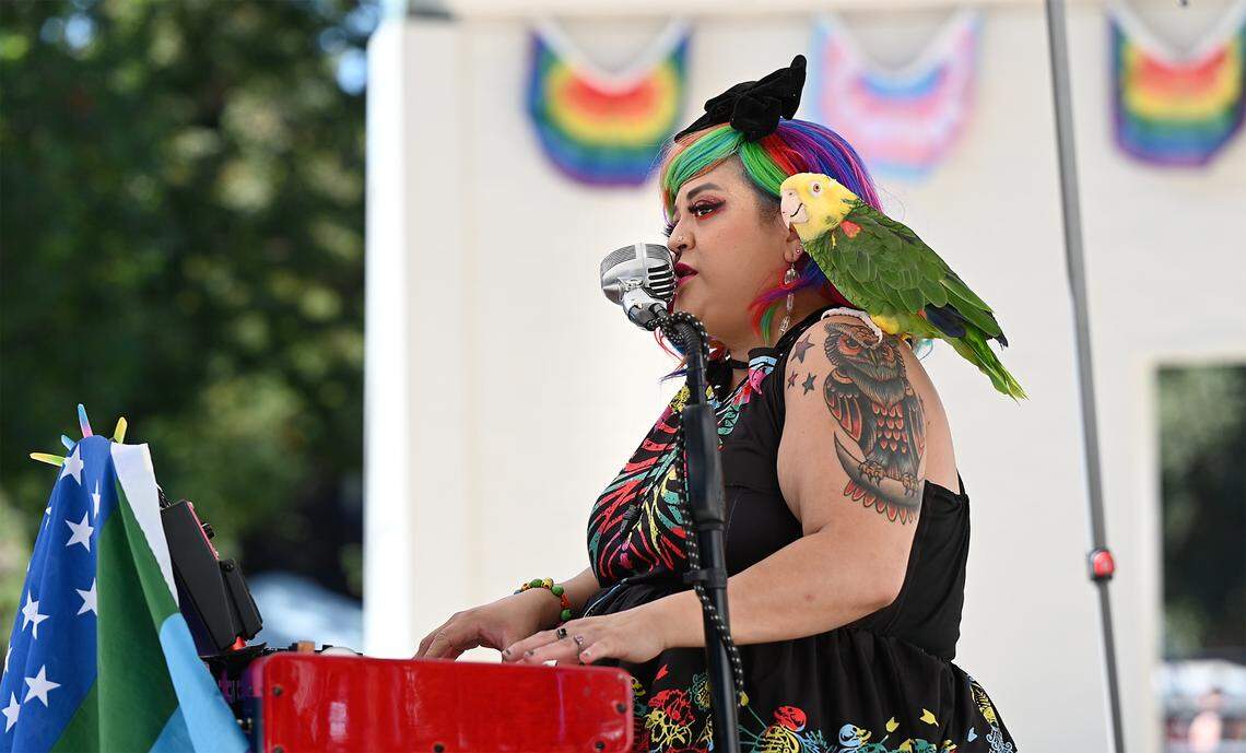 Melynda Rodriguez performs on the keyboard with her parrot Kauai during the MoPride festival at Graceada Park in Modesto, Calif., Saturday, Oct. 1, 2022.