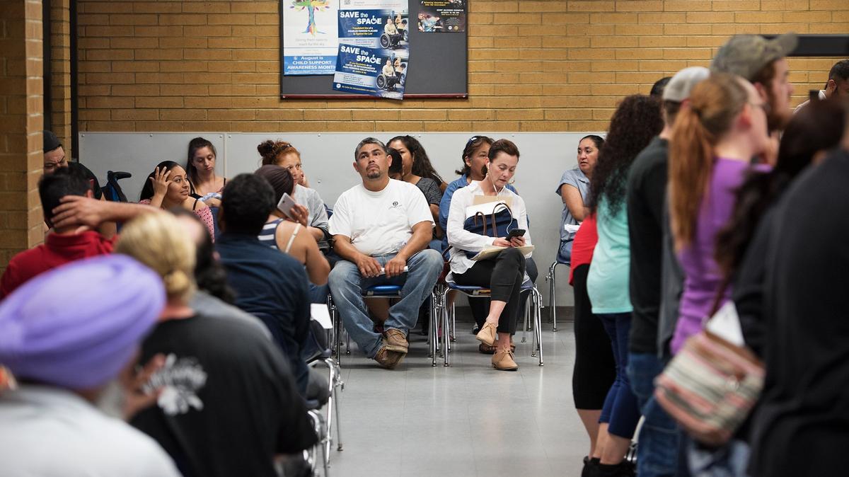 People wait in the lobby at the California Department of Motor Vehicles office in Modesto, Calif., on Friday, June 22, 2018.