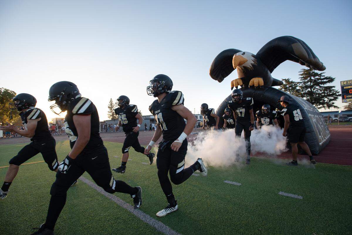Enochs players run out of the eagle tunnel before the start of the Sylvan Bowl with Beyer at Downey High School in Modesto, Calif., on Friday, August 19, 2022. Enochs won the game 35-6.