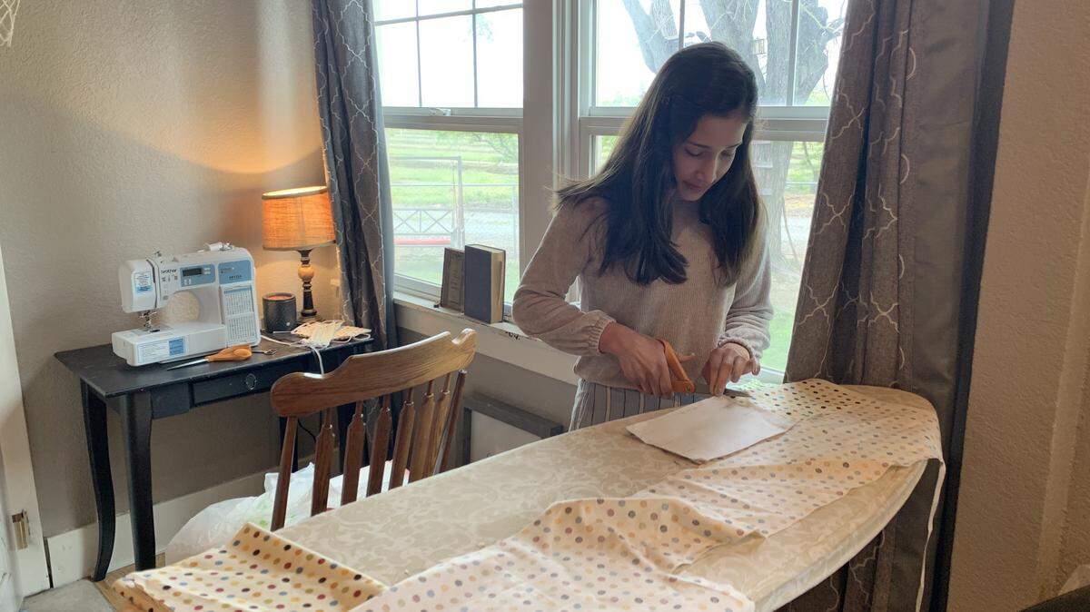 Olivia Garza, a home-schooled eighth-grade student in the Hickman Community Charter District, sews masks for health care workers on the front lines during the coronavirus pandemic.