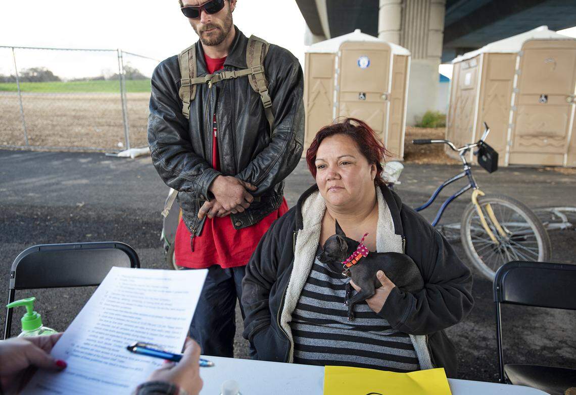 Genie Garcia and Lloyd Madewell go through registration process at the new Modesto Outdoor Emergency Shelter for the homeless under the Ninth Street Bridge in Modesto, Calif., Wednesday, Feb. 20, 2019.