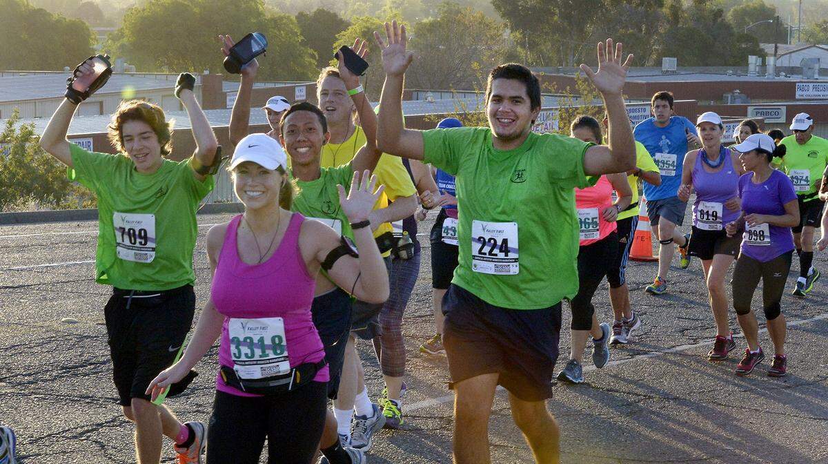 In the 2014 Modesto Marathon Teens Run Modesto members wearing green T-shirts, including bib #709, Trevor Wingate, and #224, Matthew Gonzalez, climb North Ninth Street toward North Carpenter Road.