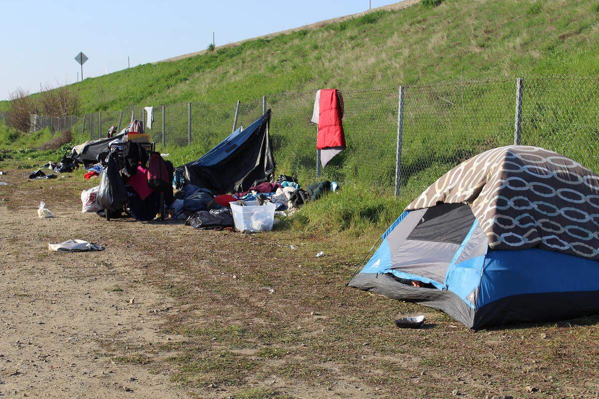 Tents line a Highway 99 off-ramp in Turlock, Calif., on Feb. 4, 2022. The city is continuing a local unsheltered homeless crisis declared in July 2021.