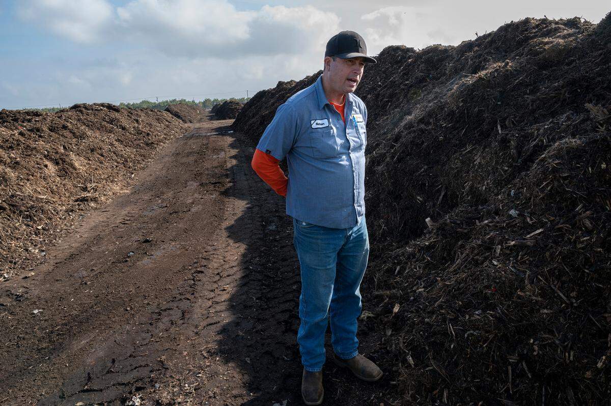 Facility supervisor Nathan Gorth stands in the rows of at the city’s compost facility west of Modesto on Nov. 17, 2021. 