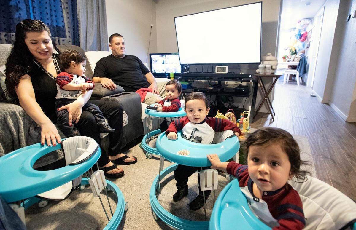 Parents Tania and Rene Villanueva with their 1-year-old quadruplets at their home east of Hughson, Calif., on Thursday, Dec. 16, 2021. Andrew was born at 2:36 p.m. on New Year’s Eve of 2020, followed over six minutes by Julian, Samuel and finally Robert.