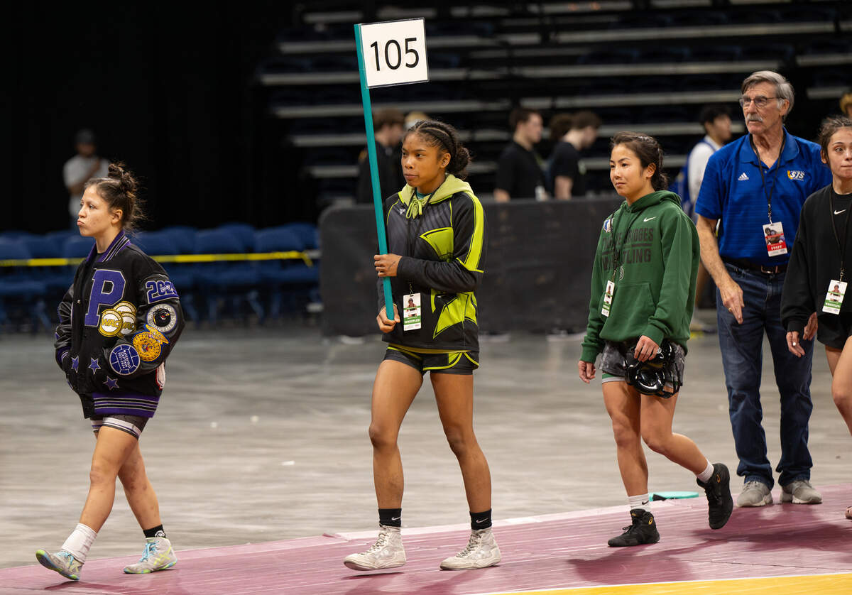 Grace Davis’ Jazmine Turner, middle, and other wrestlers are introduced before the start of the title matches at the Sac-Joaquin Section Masters Wrestling championships at Adventist Health Arena in Stockton, Saturday, Feb. 22, 2025.