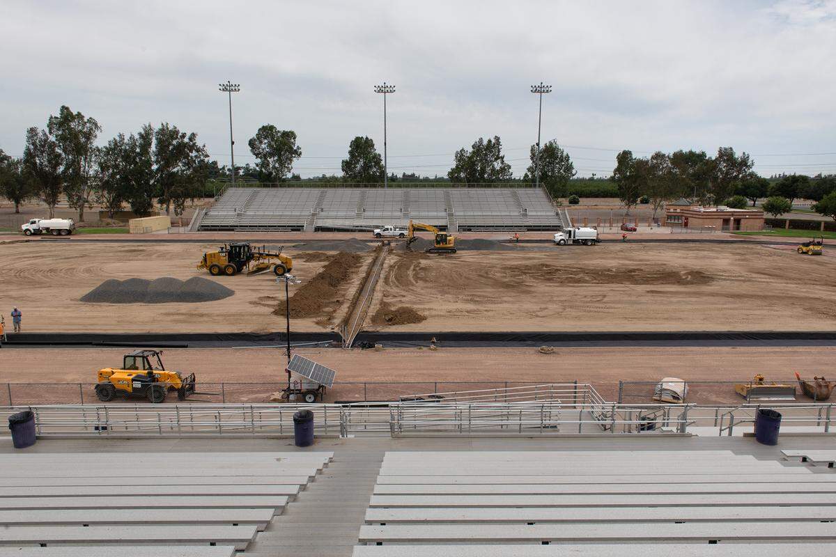 A crew works on the foundation for a new artificial turf at Johansen High School in Modesto, Calif., on Friday, August 5, 2022.