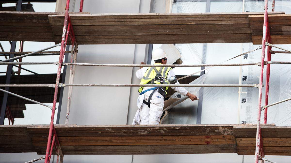 Workers patch cracks in stucco siding on 10th Street Place in Modesto, Calif., Tuesday, Nov. 20, 2018. 