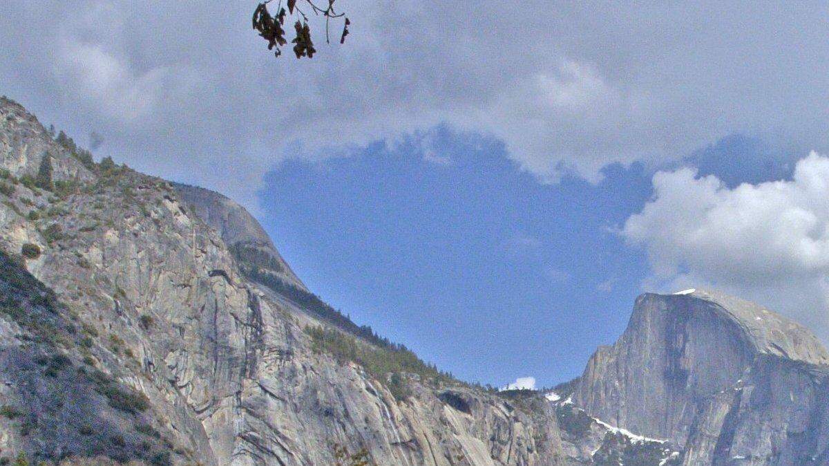 Parque Nacional de Yosemite. El tráfico sale de Yosemite Village por la carretera del Norte, con Half Dome al fondo.