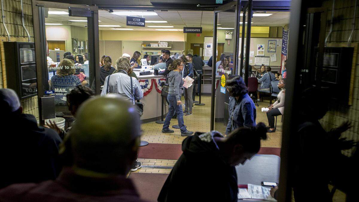 People gather at the Stanislaus County Registrar of Voters in downtown Modesto, Calif. just before 8pm as voters rush to get their ballots in Tuesday Nov. 6, 2018. 
