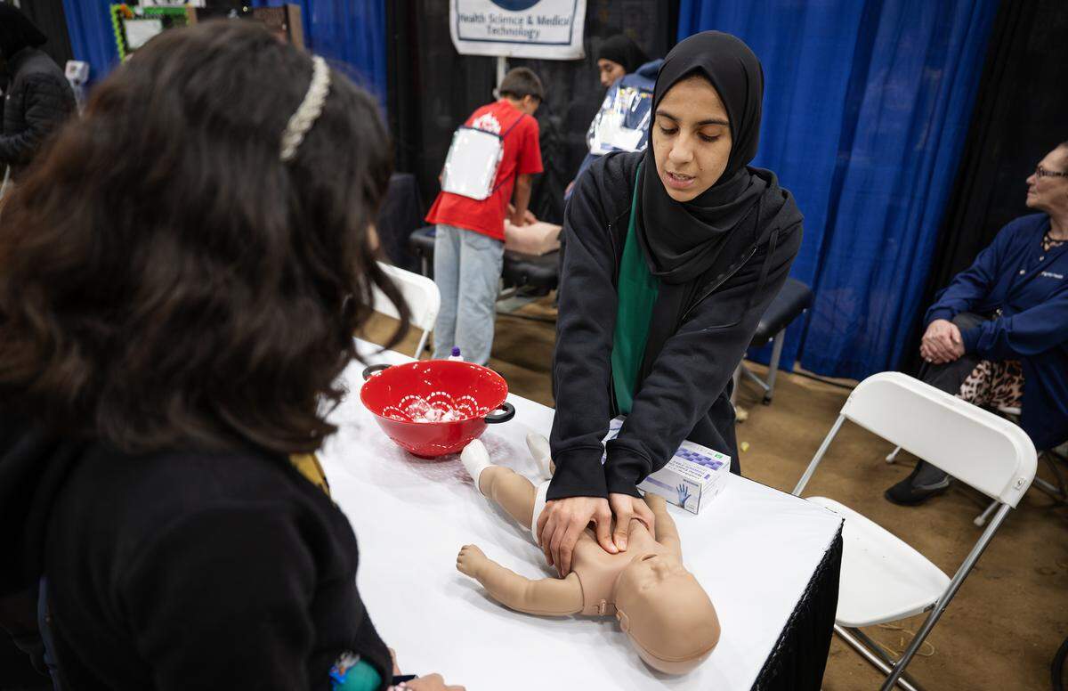 Davis High School health science and medical technology student Meena Alizai demonstrates how to perform CPR on an infant during a career-readiness event on the Modesto Junior College West Campus on  Tuesday, Dec. 2, 2025.
