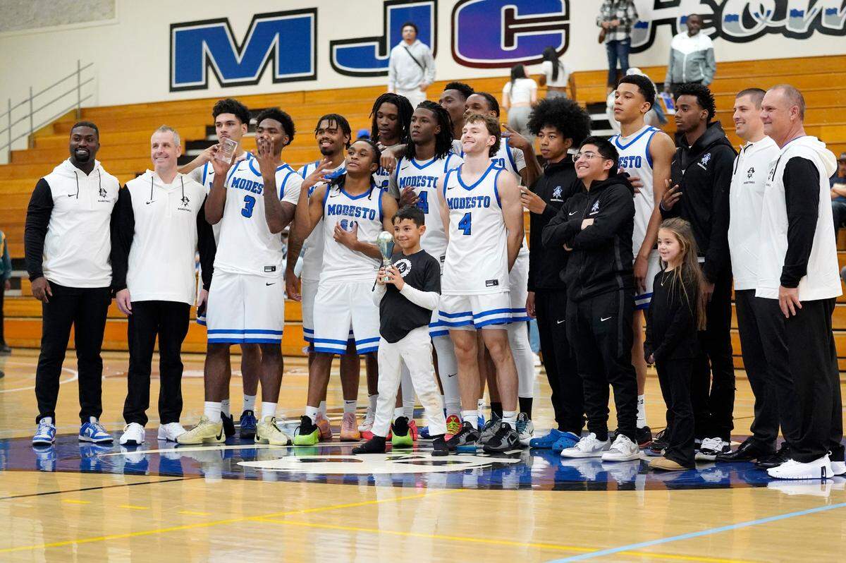 The Modesto JC men’s basketball team takes a picture with the trophy after winning the 86th Annual Men’s Basketball Tournament championship over Merced College. It is the first time MJC has won the tournament since 1945.