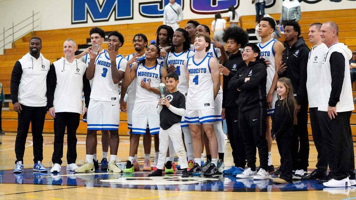 The Modesto JC men’s basketball team takes a picture with the trophy after winning the 86th annual Men’s Basketball Tournament championship over Merced College. It was the first time MJC has won the tournament since 1945.