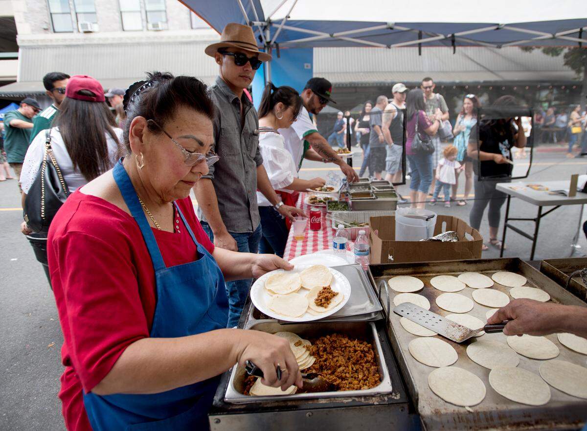Maria Aguilar prepares tacos from the Sushi Litto tent during Modesto Taco Fest in Modesto, Calif., Friday, May 5, 2018.
