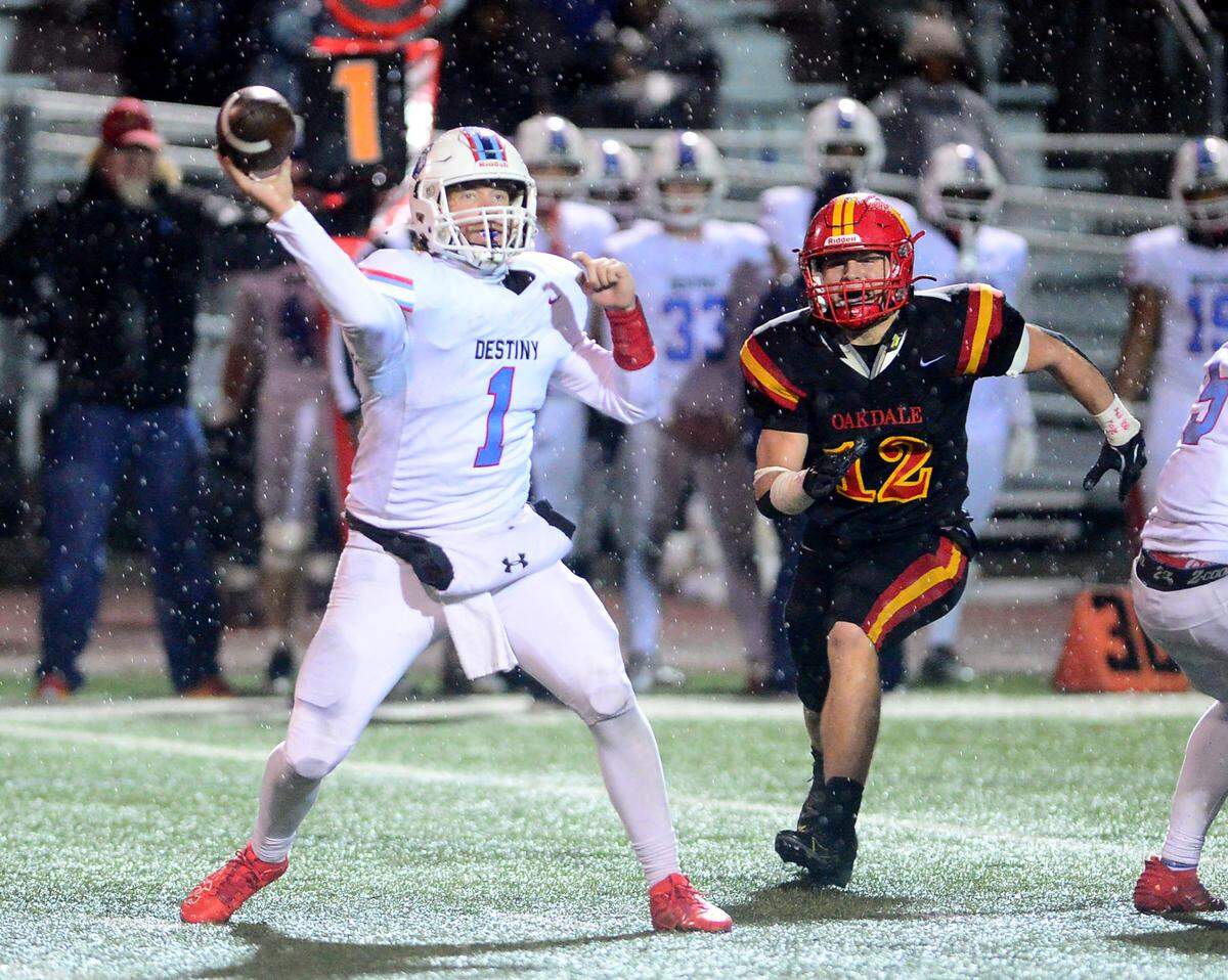 Destiny Christian Academy quarterback Dallas Munn (1) throws a pass to the flat while being pressured by Oakdales Wes Burford (12) during a 2024 CIF Sac-Joaquin Section Division 3 playoff game between Oakdale High School and Destiny Christian Academy at Oakdale High School in Oakdale California on November 22, 2024. Oakdale won the game 49-35.