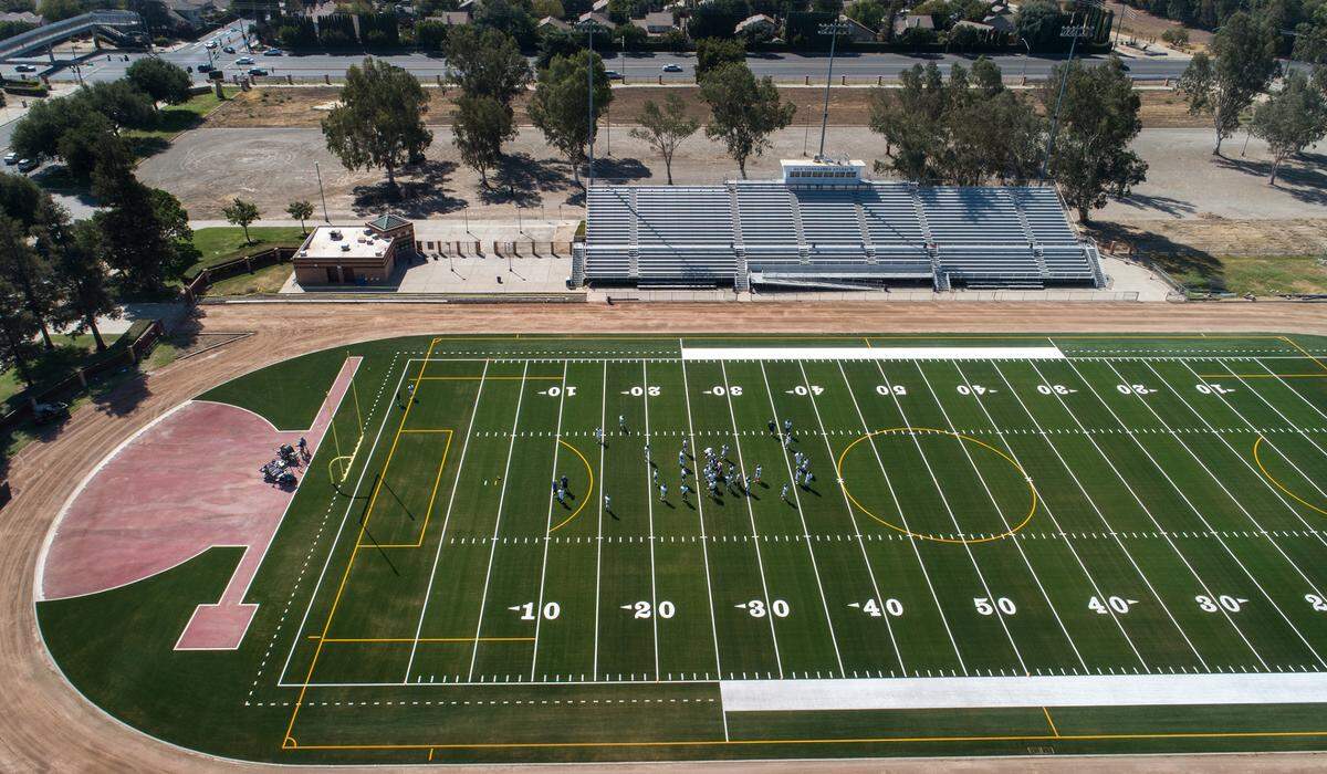 Members of the varsity football team practice for the first time on the new synthetic turf field at Johansen High School in Modesto, Calif., on Thursday, September 1, 2022.