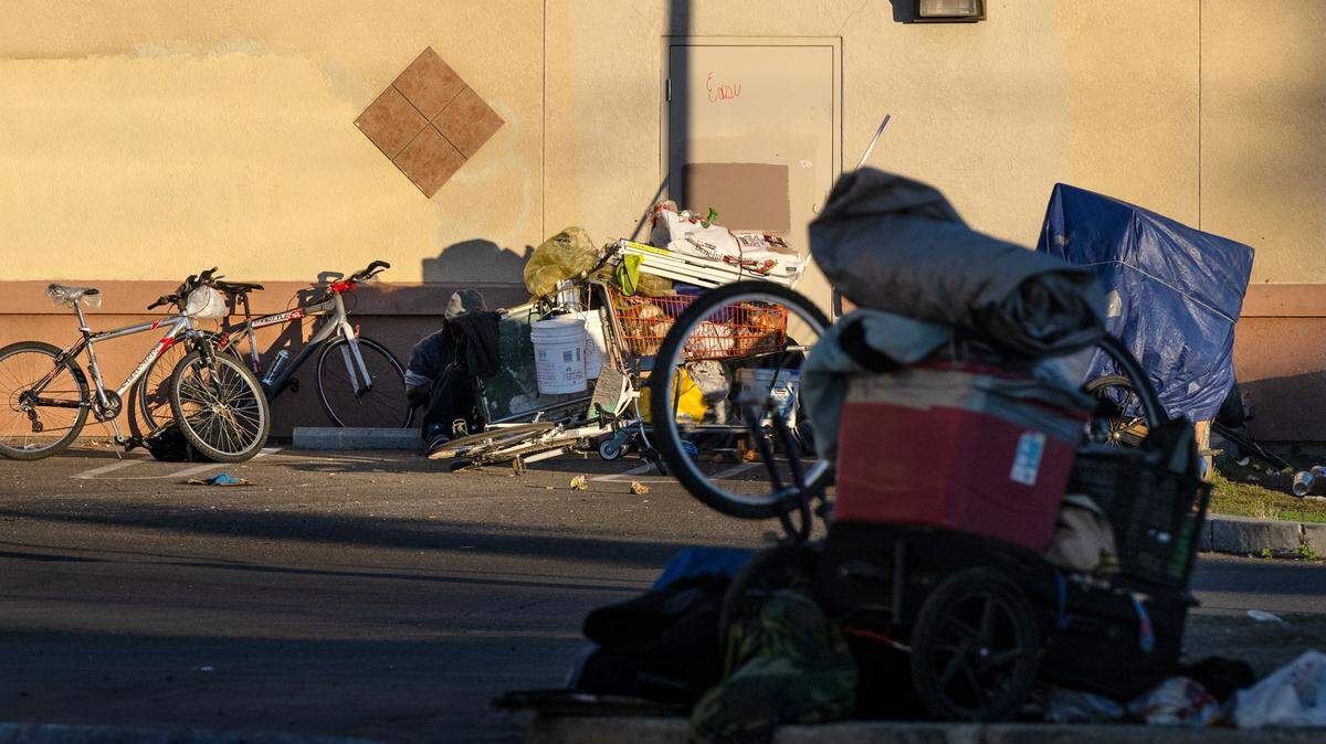 Personas sin hogar almacenan sus pertenencias detrás de un centro comercial en Hatch Road en Ceres, California, el viernes 22 de diciembre de 2023.