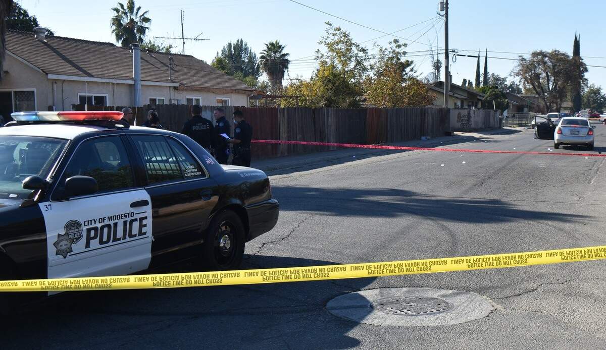 Modesto police personnel huddle at the scene of a fatal shooting near the intersection of Spokane Street and Amador Avenue in south Modesto on Sunday afternoon, Nov. 15, 2020.