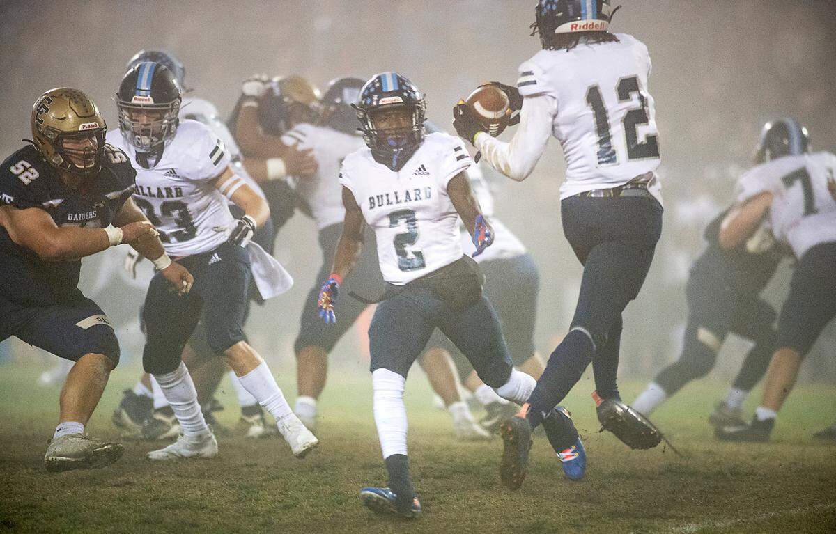 Bullard’s Jalyn Utendahl pitches the ball to teammate Daizon Allen (12) during the CIF Division II Northern California Regional Championship game with Central Catholic at Central Catholic High School in Modesto, Calif., Dec. 3, 2021. Central Catholic won the game 44-41.
