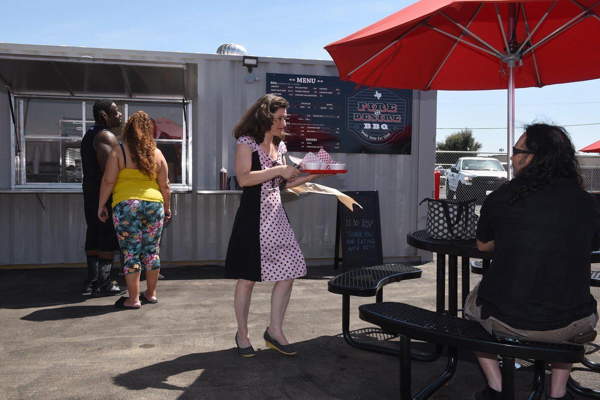Liv DeJong returns to her table with her order on Thursday August 22, 2019 at Fire and Desire BBQ located in Grub Hubs in downtown Modesto, Calif.
