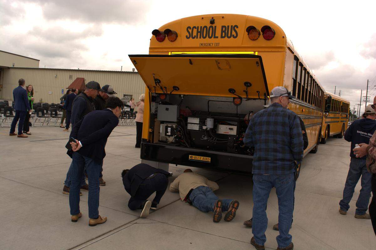 Visitors check out one of the new electric buses for Modesto City Schools, including the underside, on Tuesday, April 19, 2022
