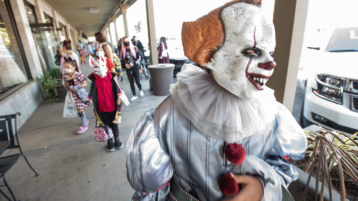 Genaro Castellana, 12, is dressed up as Pennywise as children and parents stop by shops for treats during “Trick Or Treat the Village” at McHenry Village in Modesto, Calif., on Saturday Oct. 31, 2020.