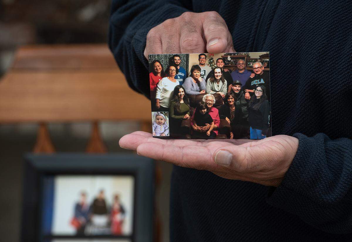 David Ramirez holds a family photo in Modesto, Calif., on Saturday, Nov. 21, 2020. David’s mother, Genevieve Ramirez, 73, and Frances Jacobo, 90, David’s grandmother died from COVID-19 complications four days apart in August.