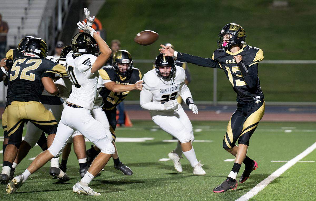 Enochs quarterback Jakob “Slim” Hilterbrand passes off the ball under pressure from Buhach Colony’s Bryson Fainter during the non-league game at Gregori High School in Modesto, Calif., Friday, Sept. 1, 2023.