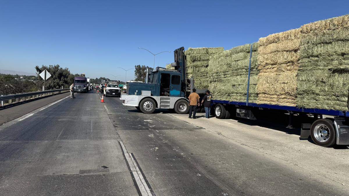 Crews work to clear hay bales and debris from a crash involving a big rig Tuesday morning on southbound Highway 99 near Crows Landing Road in Modesto.