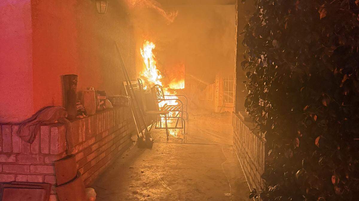 Flames burn along the front walkway of a home in the 3000 block of Burton Drive in Ceres early Monday morning. Firefighters rescued a person from inside the residence and provided life-saving care before the victim was taken to a hospital, officials said.